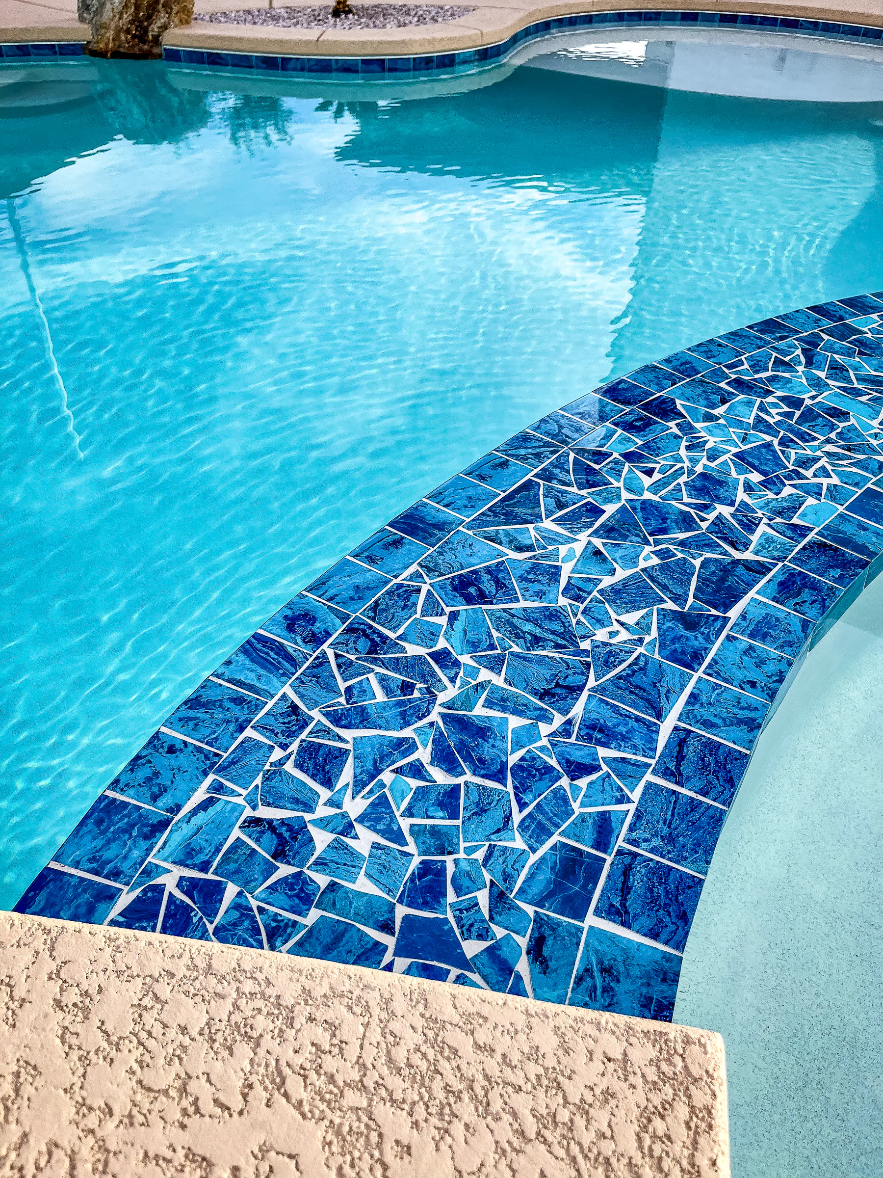Garde project showing close up blue mosaic tile pool bench