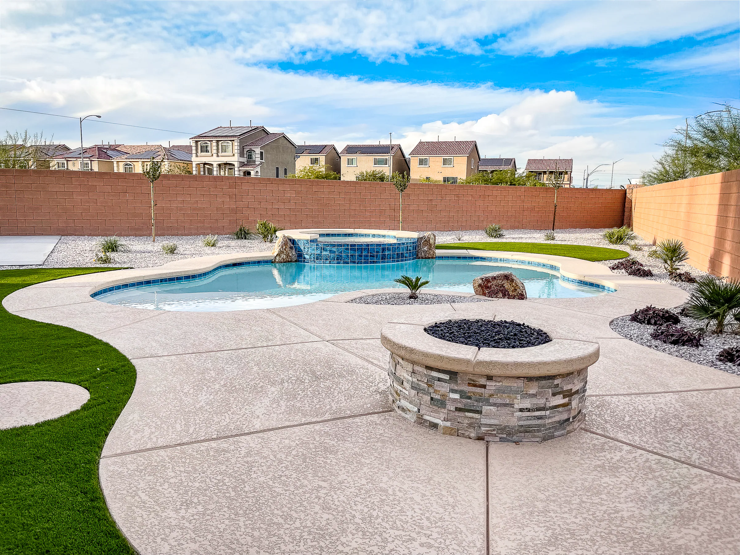 Garde project showing wide yard stone fire pit pool spa