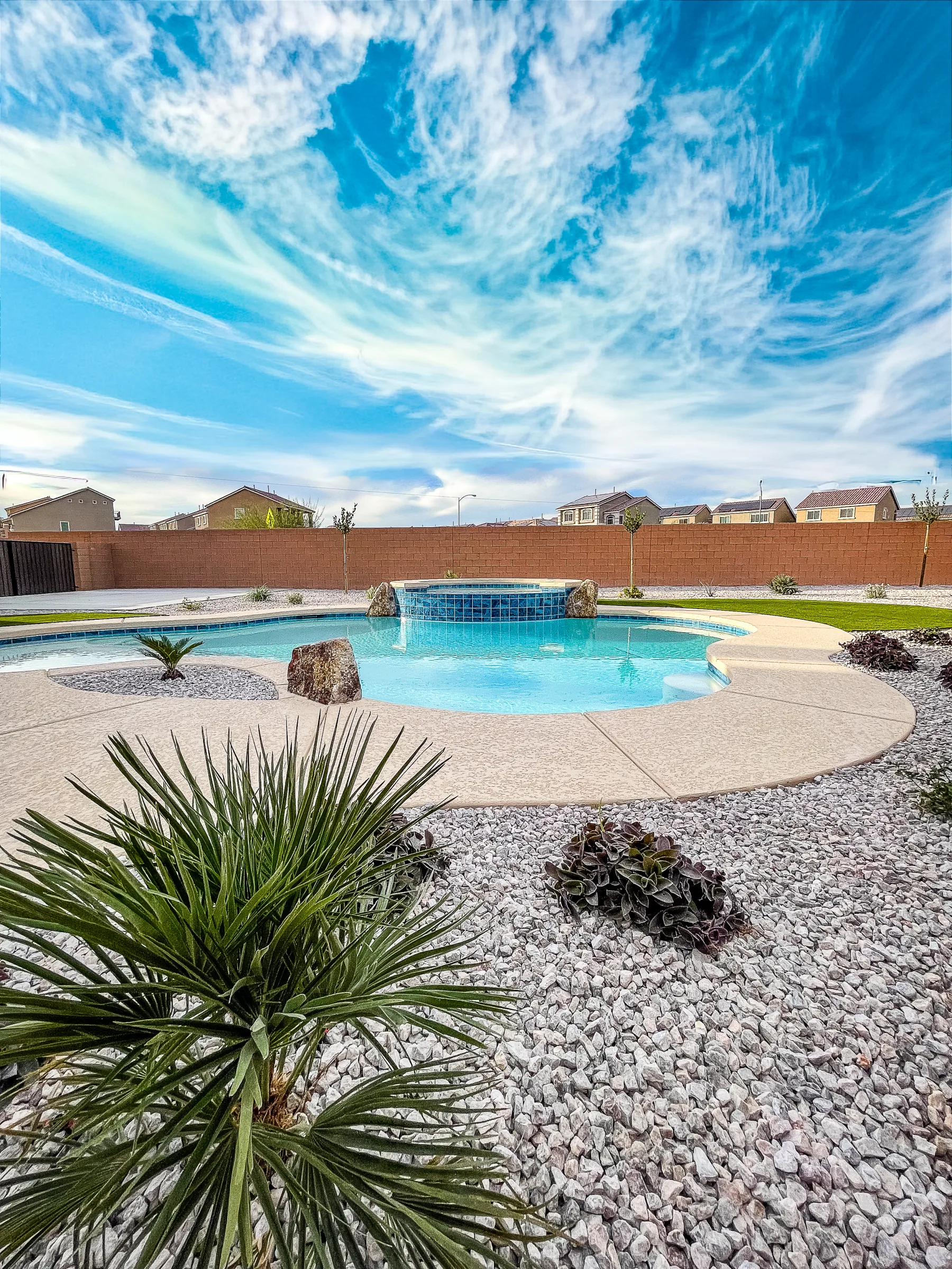 Freeform pool and raised spa beneath a dramatic Las Vegas sky