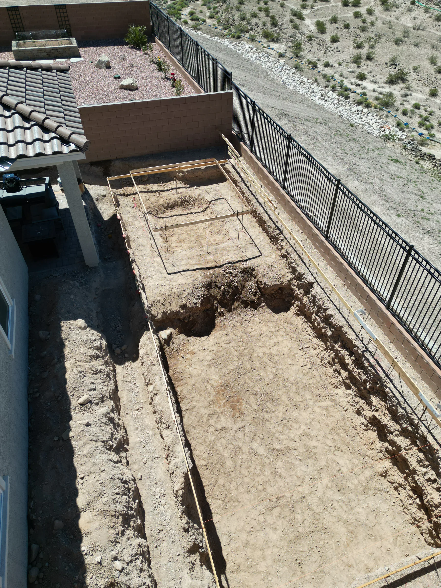 Excavated pool footprint taking shape in a Las Vegas backyard
