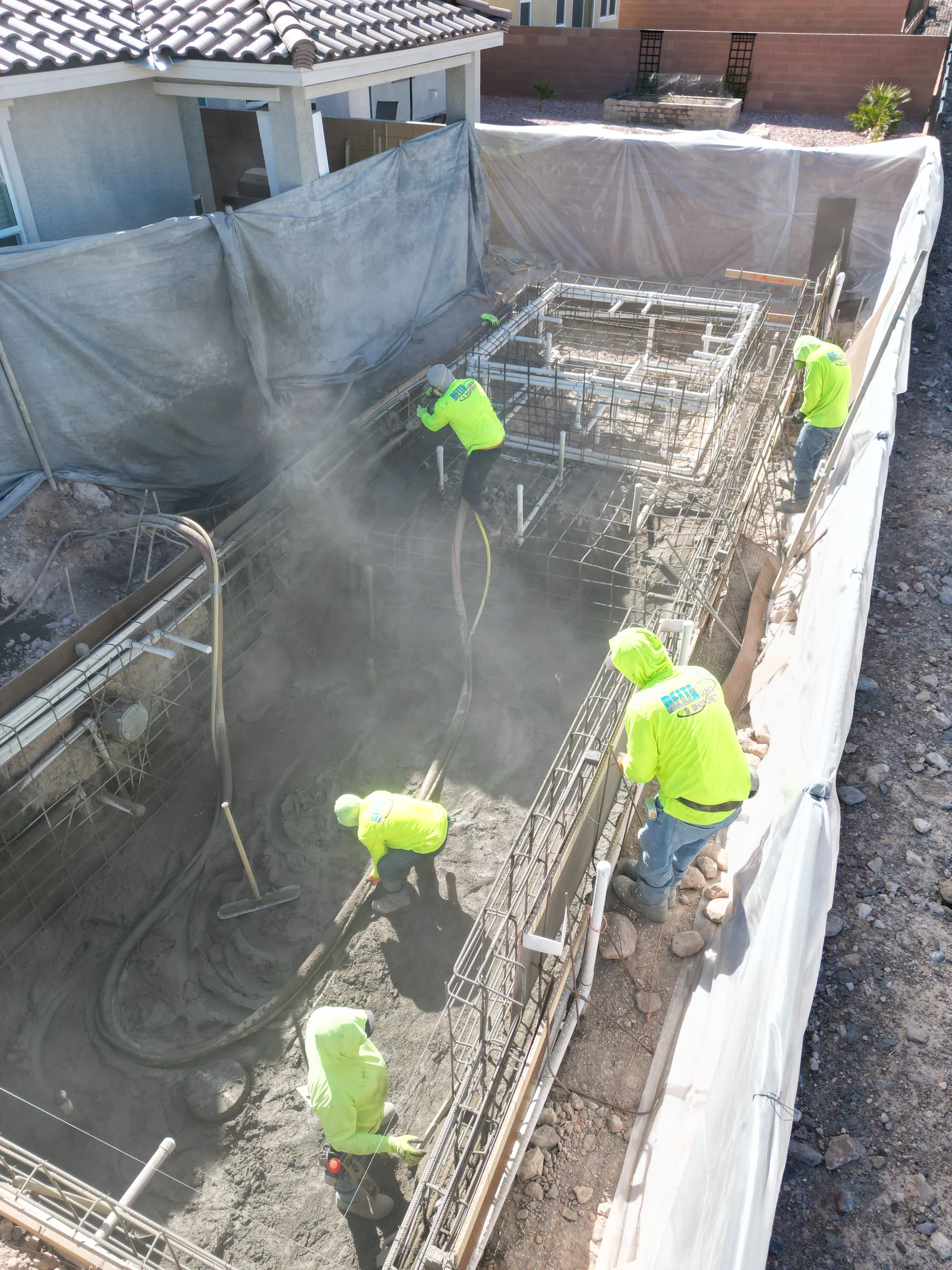 Crew applying shotcrete to form the pool and raised spa shell