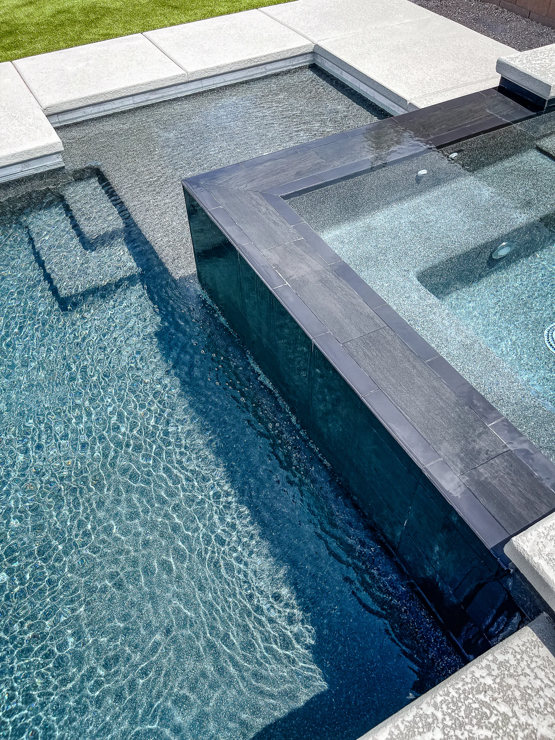 Palmer project showing closeup spa spillover edge pool steps