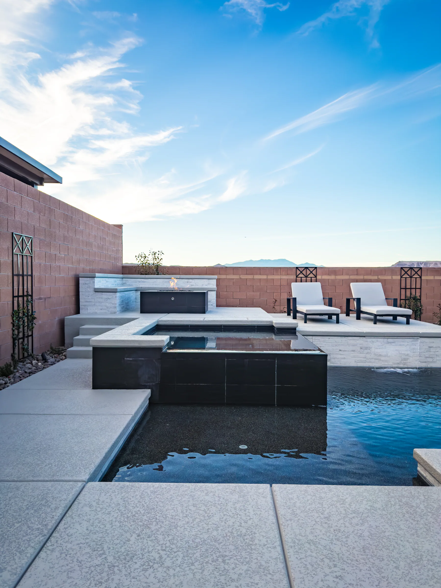 Palmer project showing wide black spa firepit ledge loungers mountain