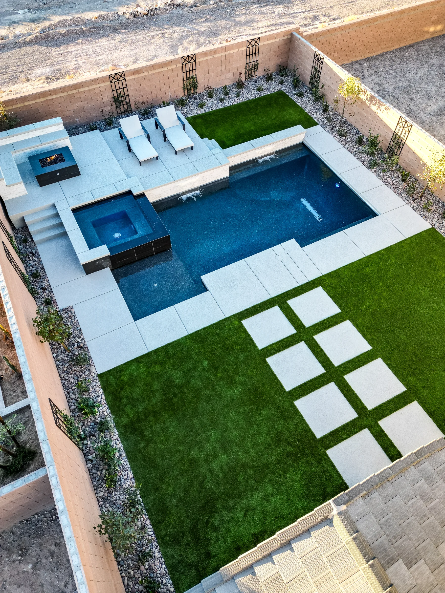 Aerial view of a full yard with pool, spa, turf, and firepit