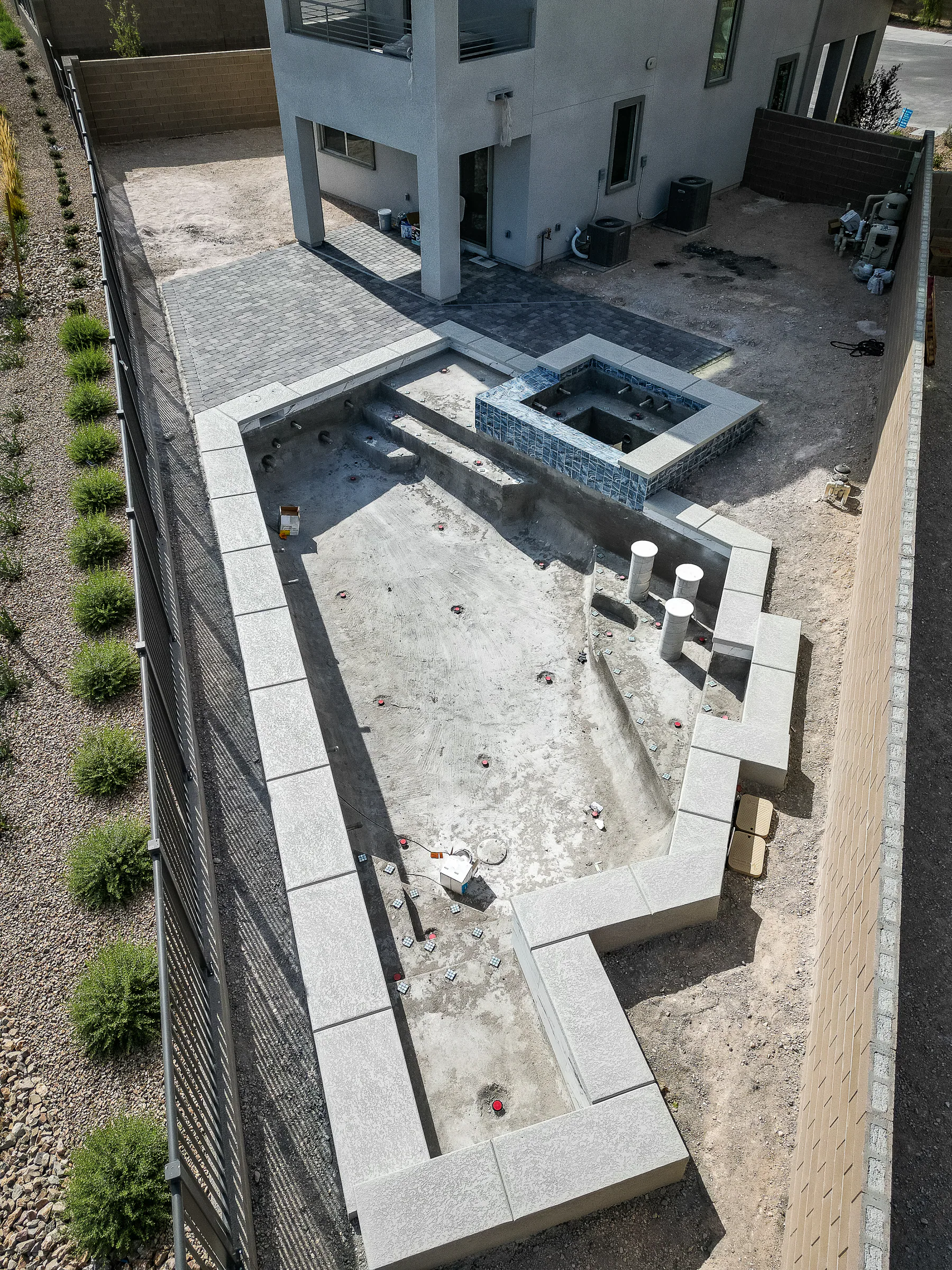 Coping installed around the stepped pool shell before the interior finish