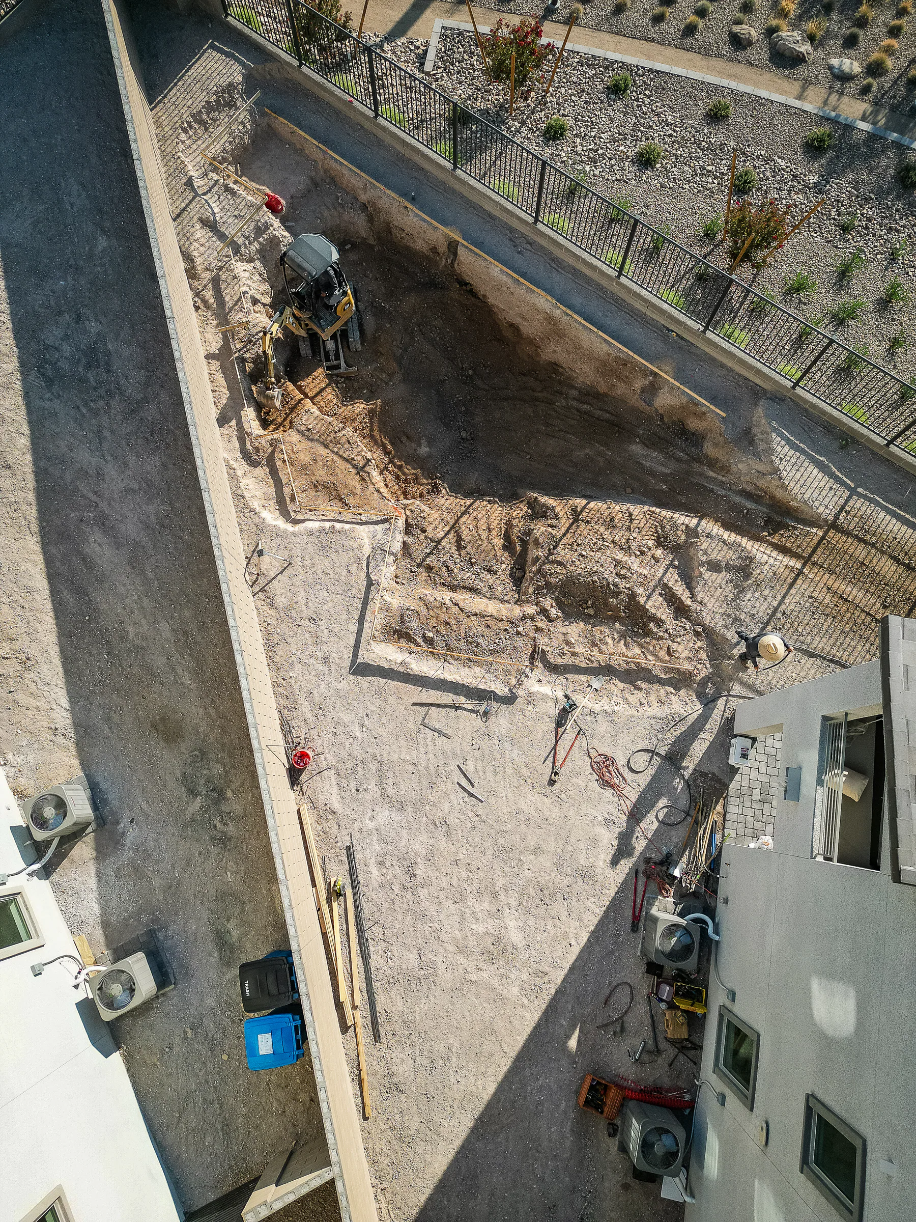 Top-down view of the excavated pool footprint beside the home