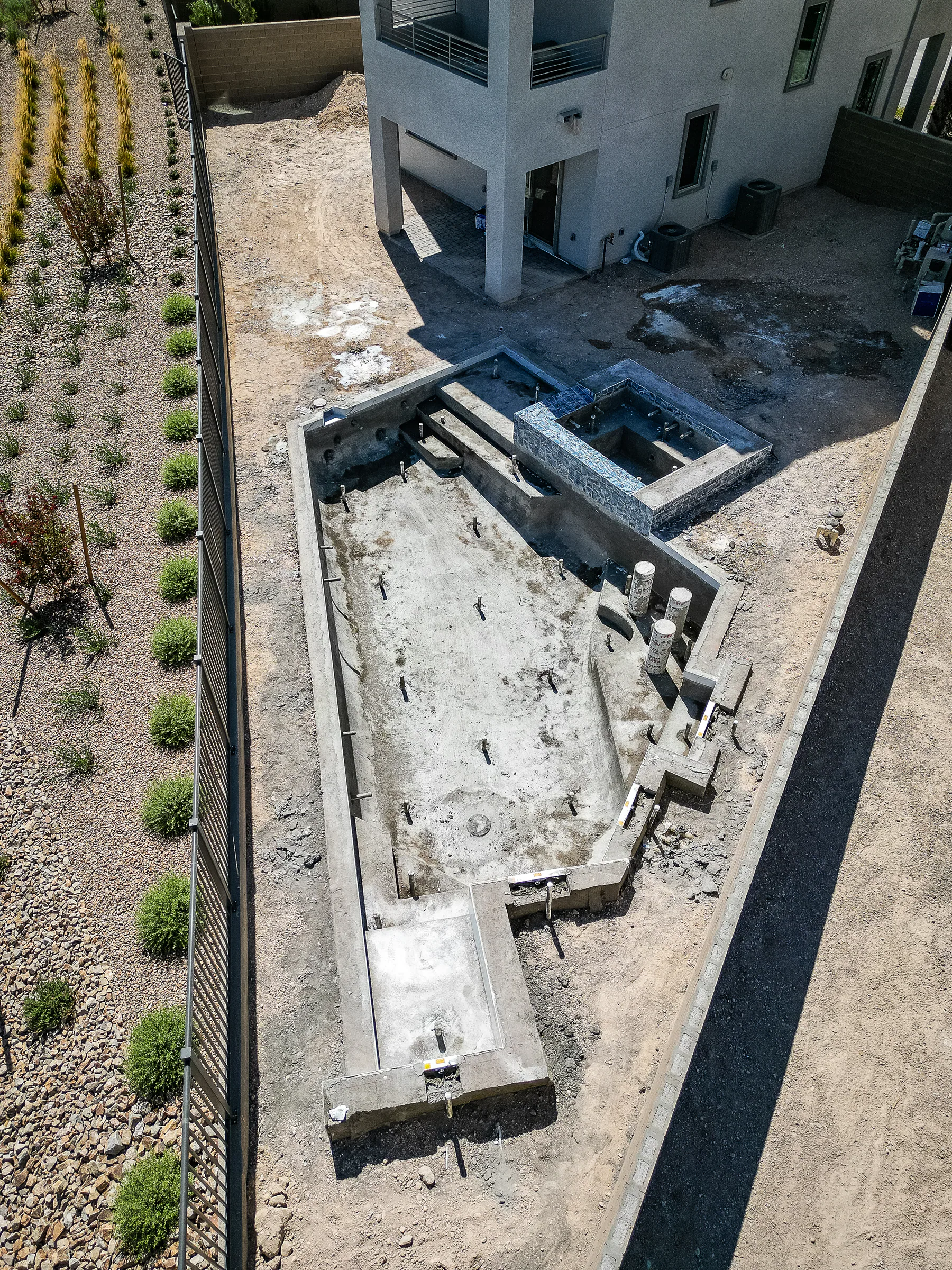 Shotcrete pool shell and raised spa walls curing in the backyard