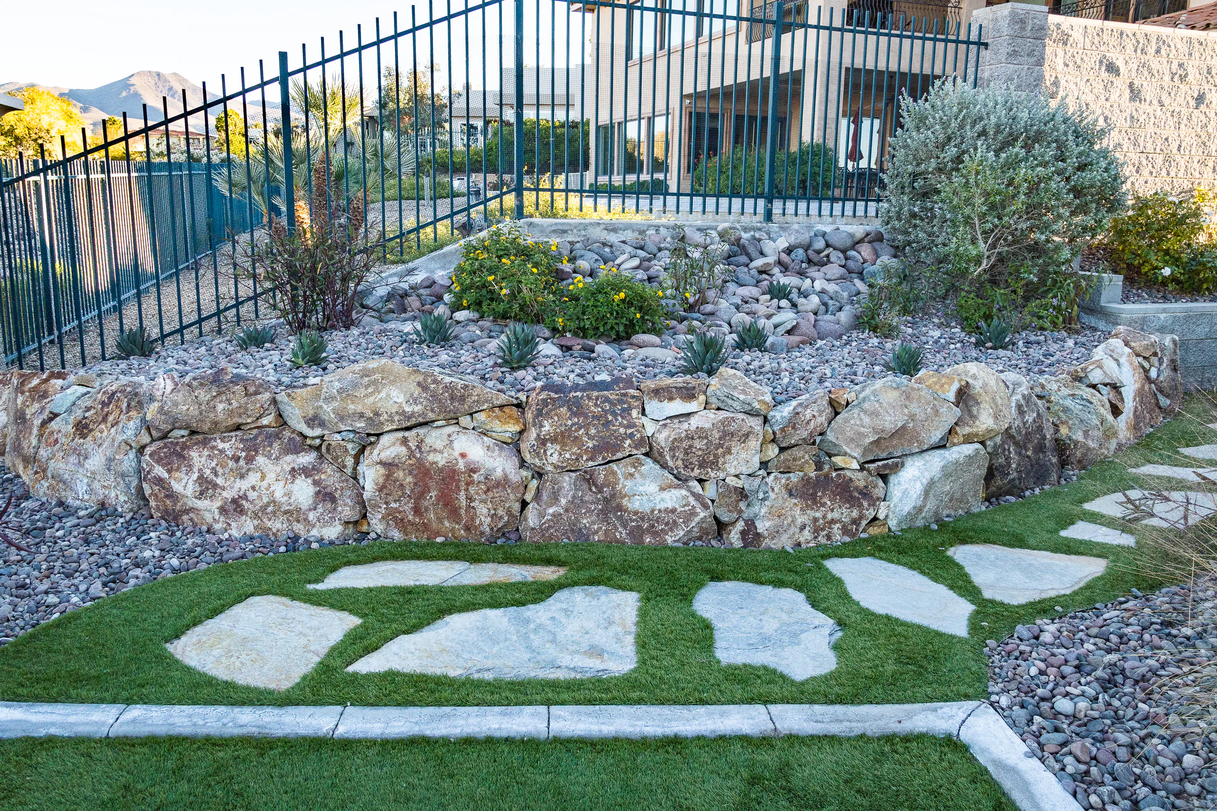 Modern pool and spa beside a limestone wall