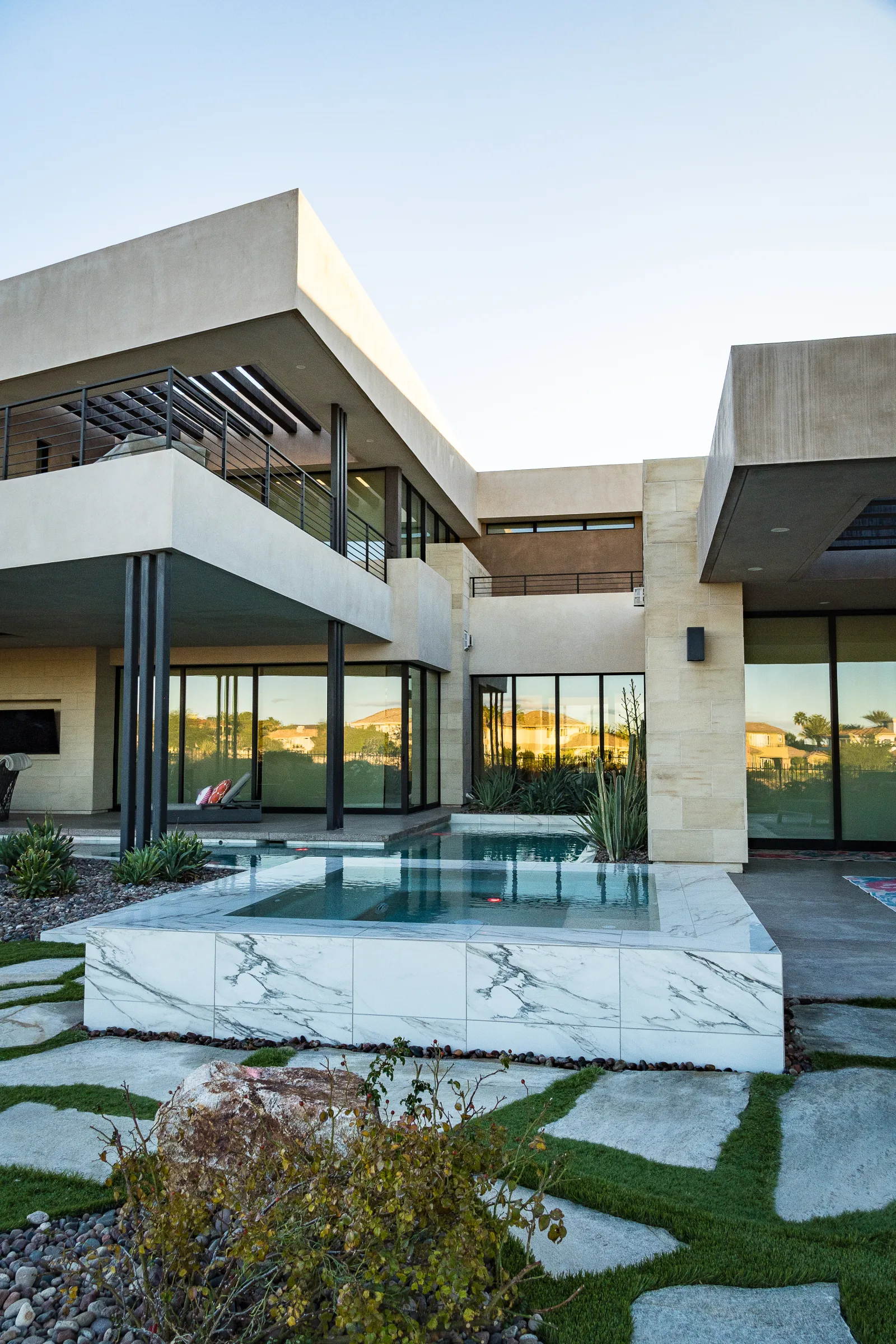Modern home with balconies beside a marble spa and pool