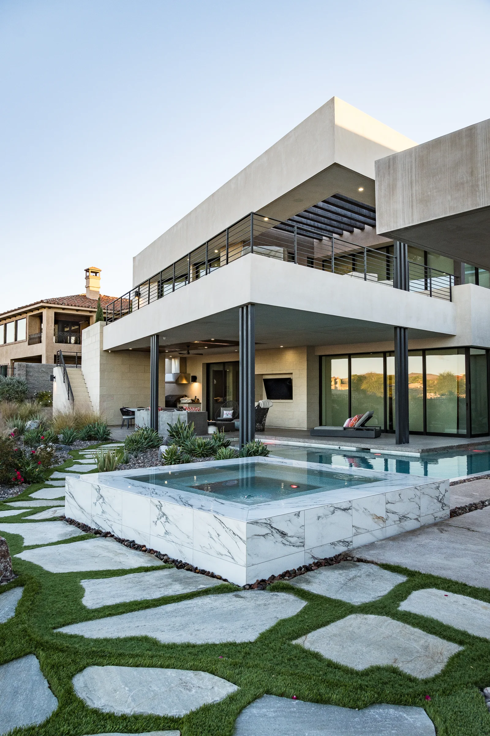 Modern pool and spa beside a limestone wall