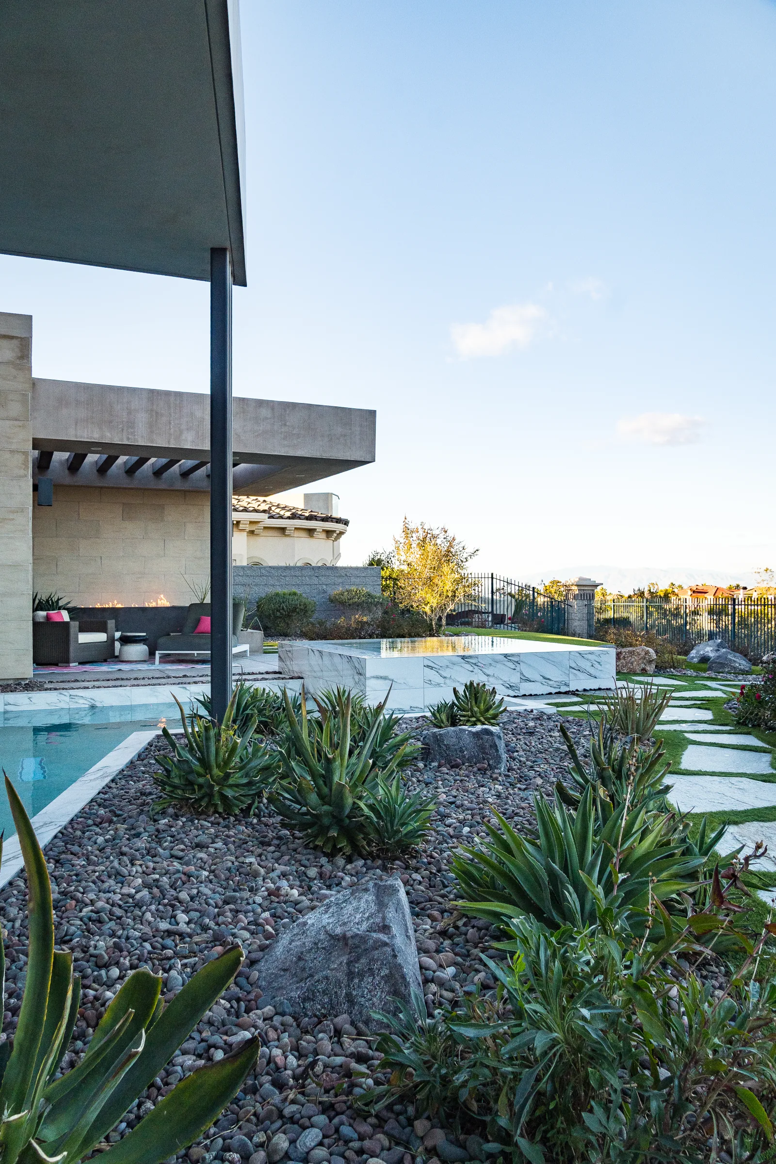 Marble spa, agave rock garden, and patio beside a modern home