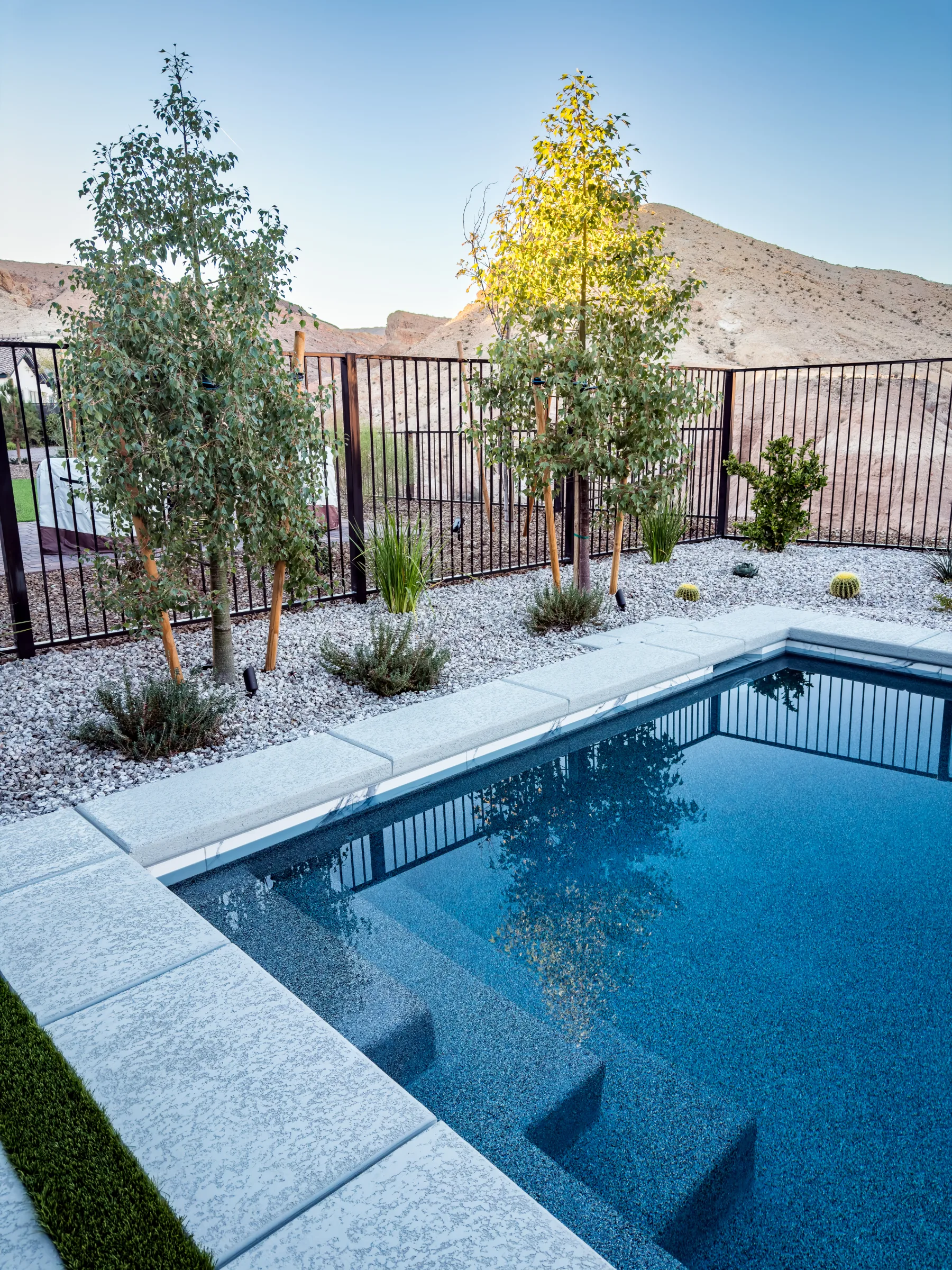 Pool entry steps beside a view fence overlooking desert hills