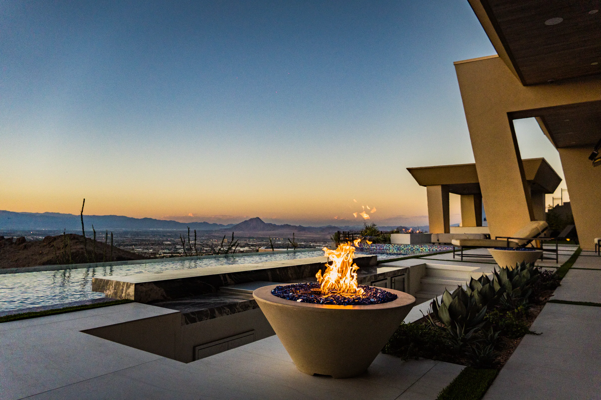 Fire bowl, agave planting, and infinity pool edge overlooking the valley at sunset