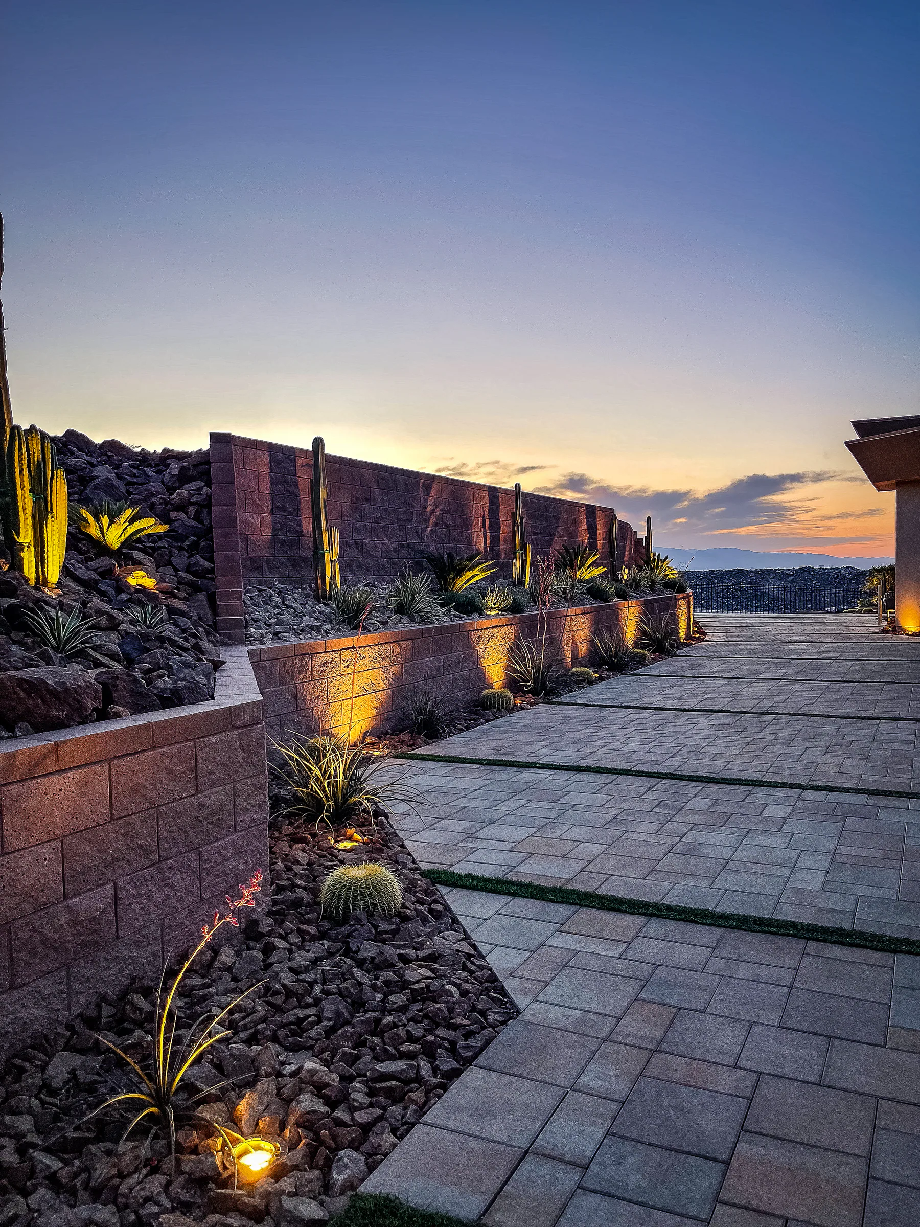 Toti project showing paver walkway terraced planters lit cacti